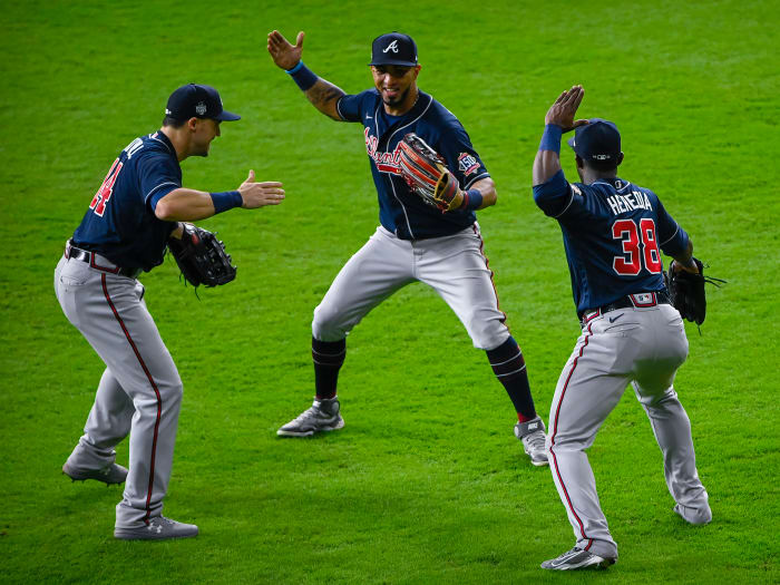 Atlanta Braves center fielder Adam Duvall (14) and left fielder Eddie Rosario (8) and center fielder Guillermo Heredia (38) celebrate the win over the Houston Astros in game one of the 2021 World Series.